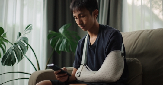 An injured man using his phone